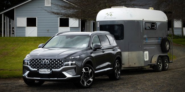 Best SUVs with High Towing Capacity in NZ - Pictured here a Hyundai Santa Fe SUV towing a horse float.