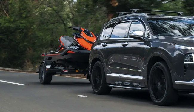 Best SUVs with High Towing Capacity in NZ - Pictured here a Hyundai Santa Fe SUV towing a jet ski.